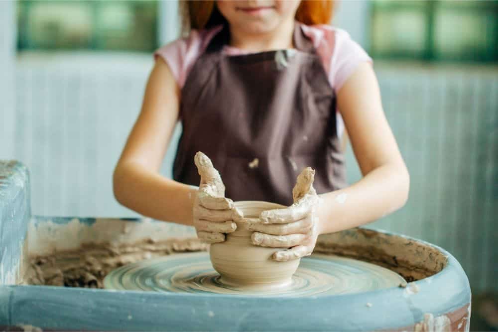 Students learning pottery in a bright, welcoming studio